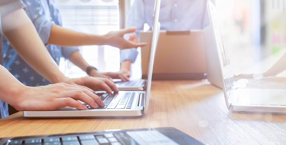 managed-offers-image People reviewing information on laptops